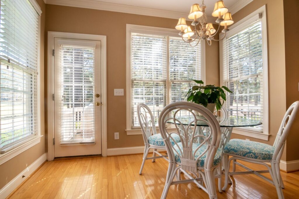 Stylish dining room with large windows and modern furnishings, bathed in natural light.