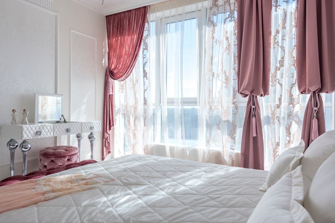 about-us-img Cozy and elegant white and rosy bedroom with comfortable bed and draped curtains
